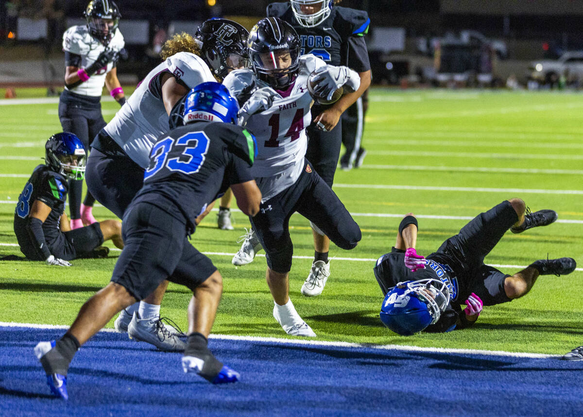 Faith Lutheran running back Cale Breslin (14) scores as Green Valley defensive end Nash Wilkins ...