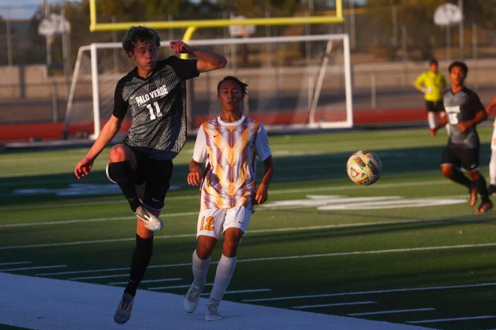 Palo Verde Noah Johnson (11) kicks the ball in front of Eldorado defender Daniel Cooke (12) dur ...