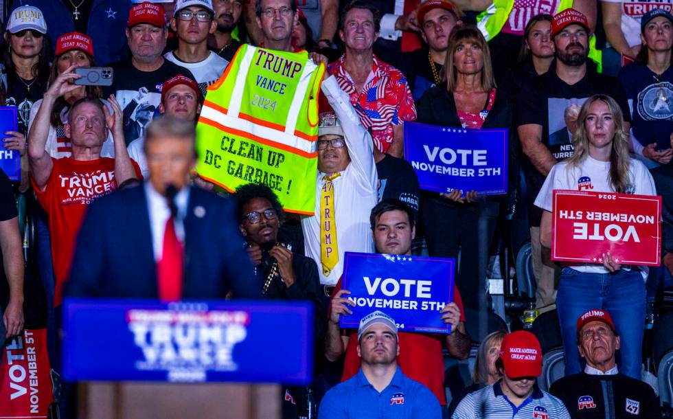 A supporter holds up a reflective vest with message as former President Donald Trump speaks dur ...