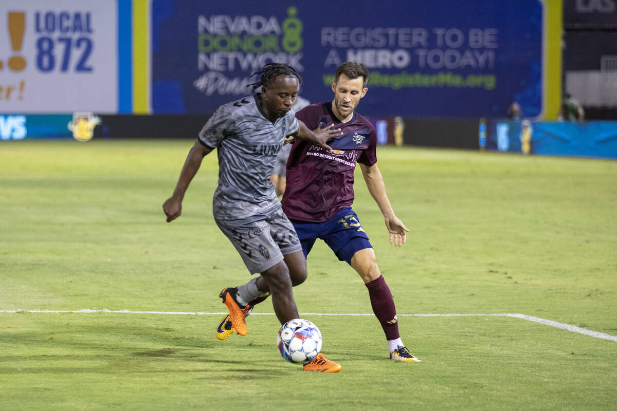 Las Vegas Lights FC midfielder J.C. Ngando (26) fends off Detroit City FC defender Matt Sheldon ...