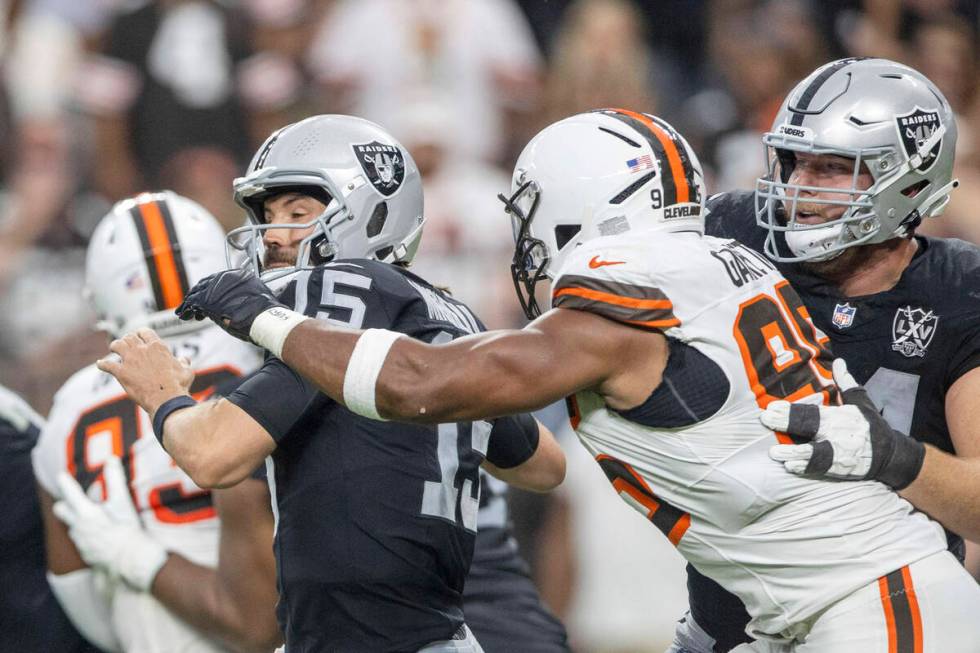 Raiders quarterback Gardner Minshew (15) is sacked by Cleveland Browns defensive end Myles Garr ...