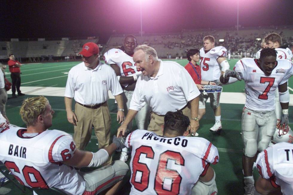 New Rebel Football head coach John Robinson shakes hands with Brandon Bair, left, and Danny Pac ...