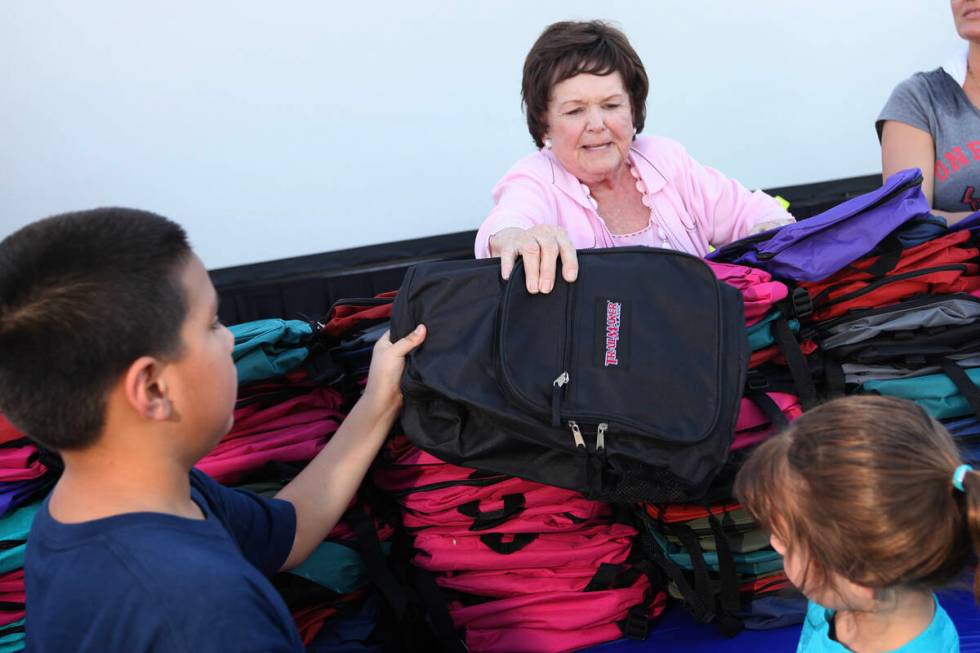 Lois Tarkanian, a member of City Council, hands out a backpack to children during the Rotary Pa ...