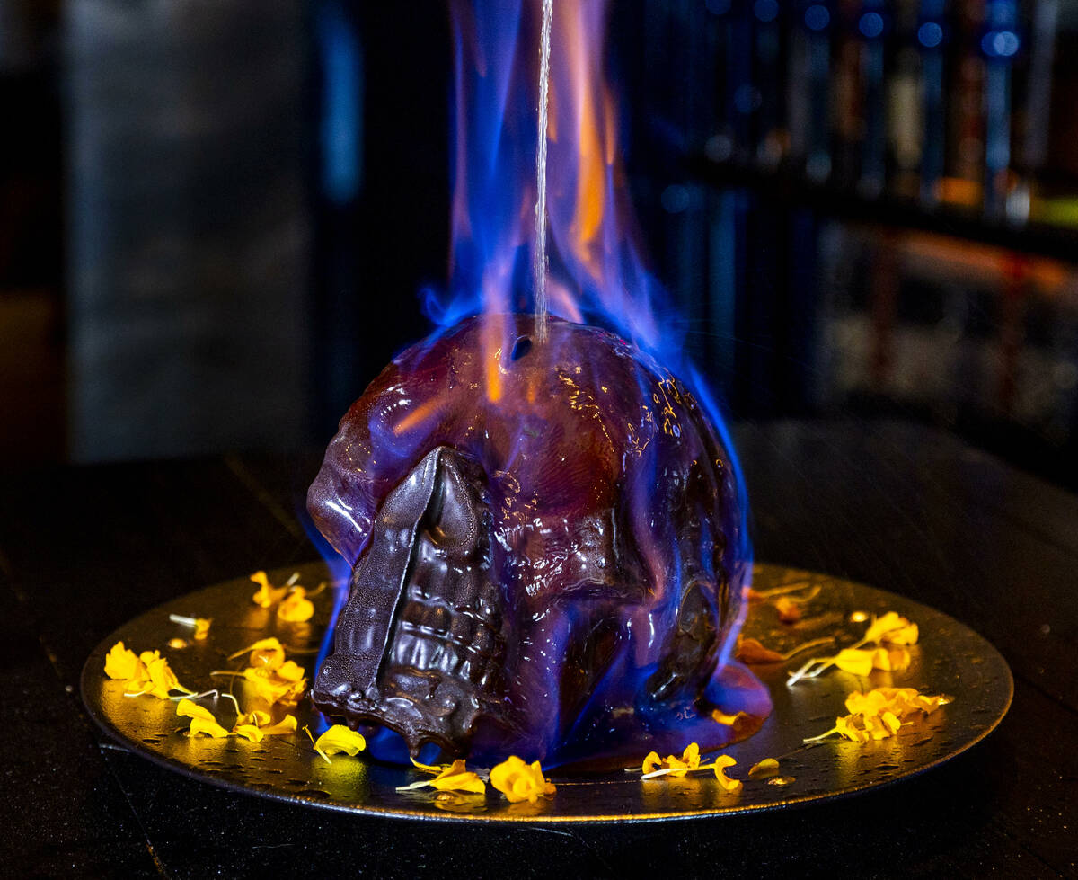 Hot chocolate mocha sauce is poured atop a Diablo Skull en Fuego dessert to reveal flan inside ...