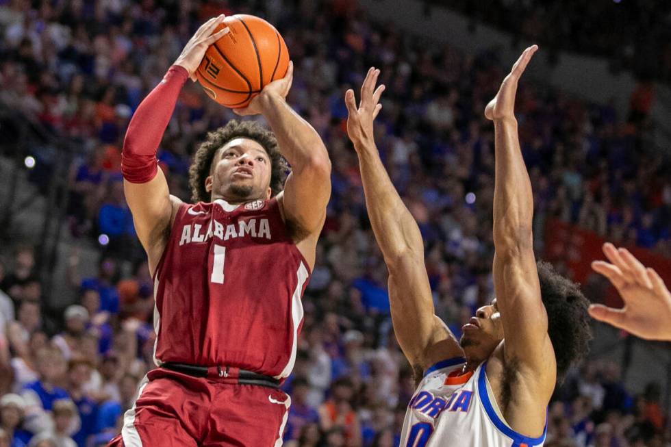 FILE - Alabama guard Mark Sears (1) shoots past Florida guard Zyon Pullin (0) during the second ...