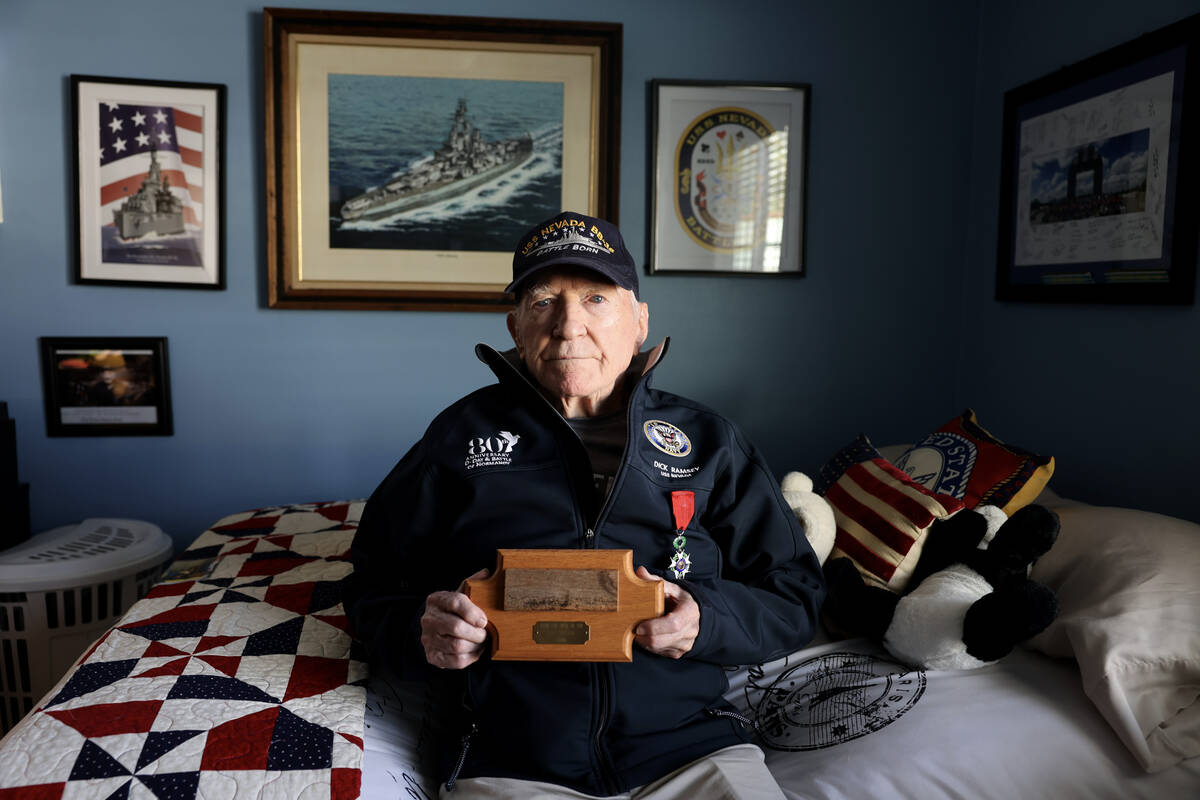 USS Nevada veteran Dick Ramsey, 101, shows a piece of the deck from the battleship at his home ...