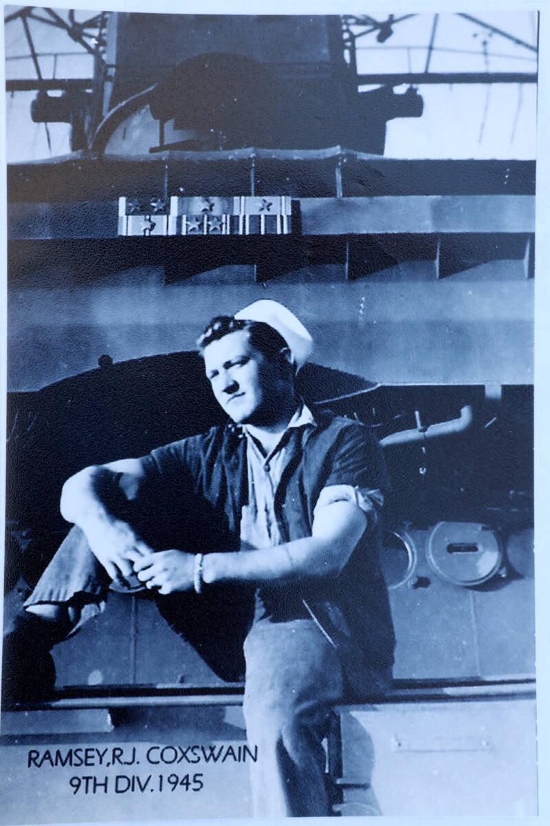 1Dick Ramsey, 101, shows a photo of himself on the USS Nevada during an interview at a restaura ...