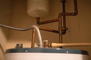 To begin replacing the nipples, turn off the valve on top of the water heater, then attach a ga ...