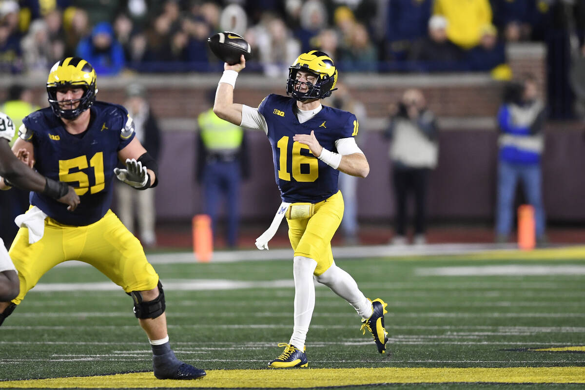 Michigan quarterback Davis Warren (16) throws against Michigan State in the second half of an N ...