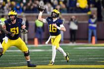 Michigan quarterback Davis Warren (16) throws against Michigan State in the second half of an N ...