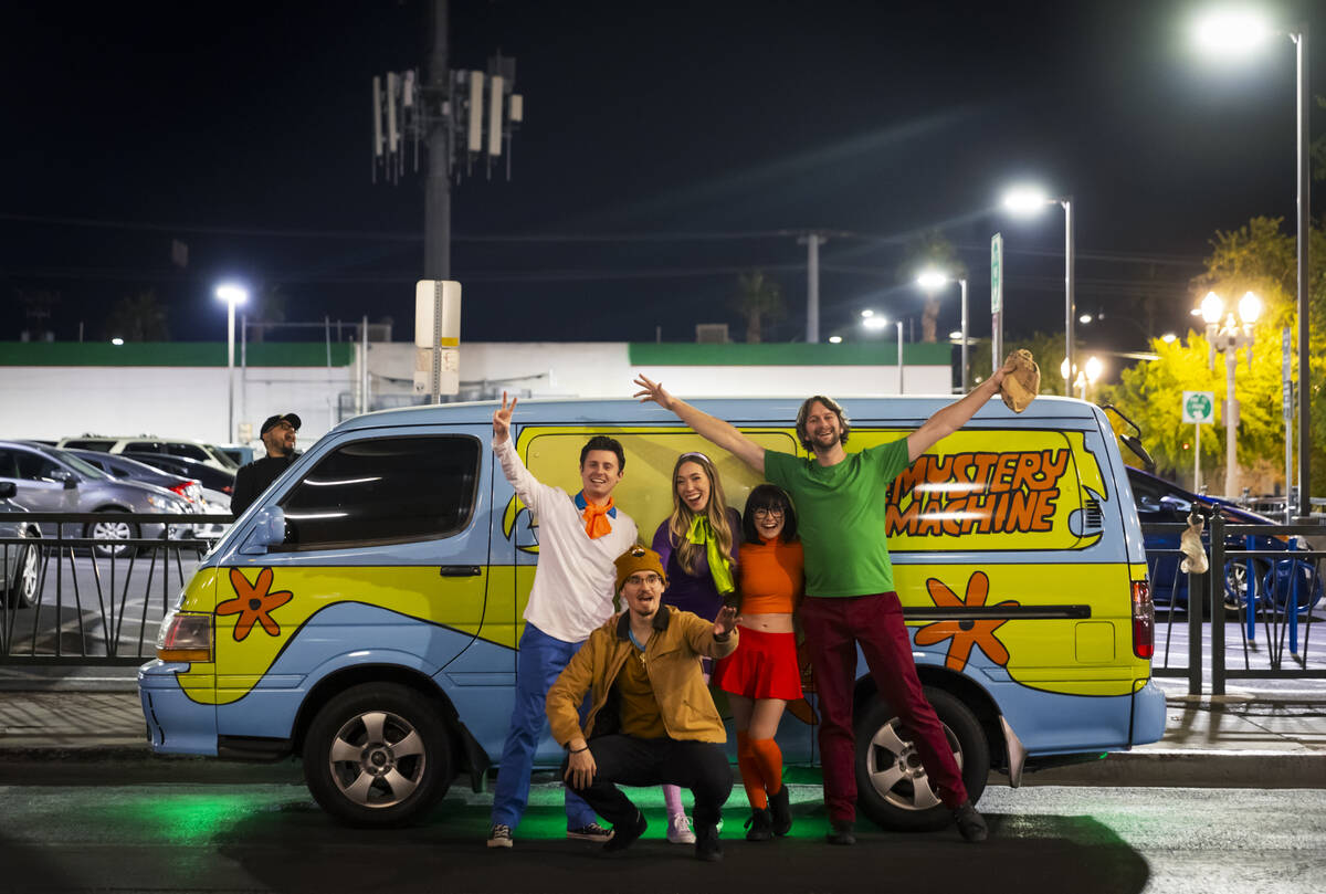 A group dressed as characters from Scooby-Doo poses with the Mystery Machine van on Ogden Avenu ...