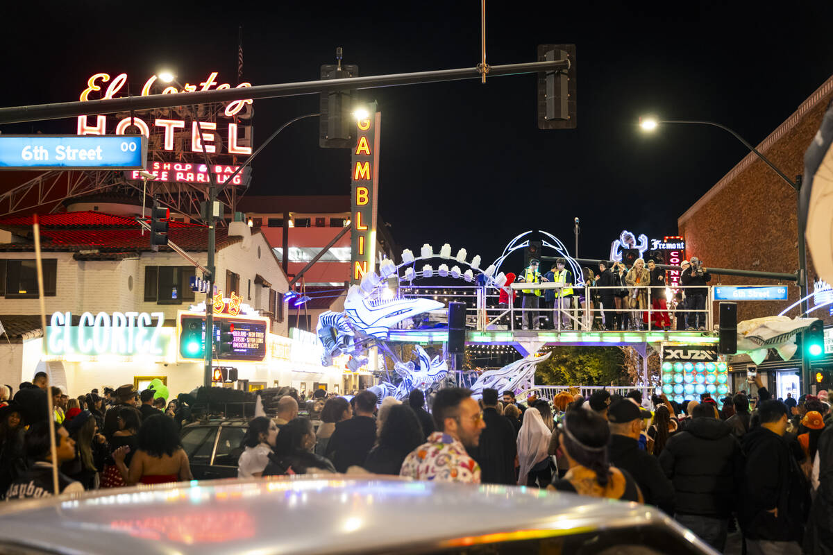 People walk along Fremont Street as DJs perform on an art car during Halloween night on Thursda ...