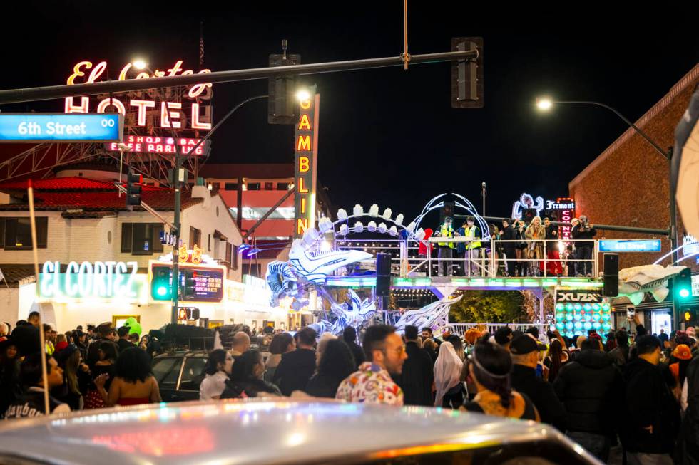 People walk along Fremont Street as DJs perform on an art car during Halloween night on Thursda ...