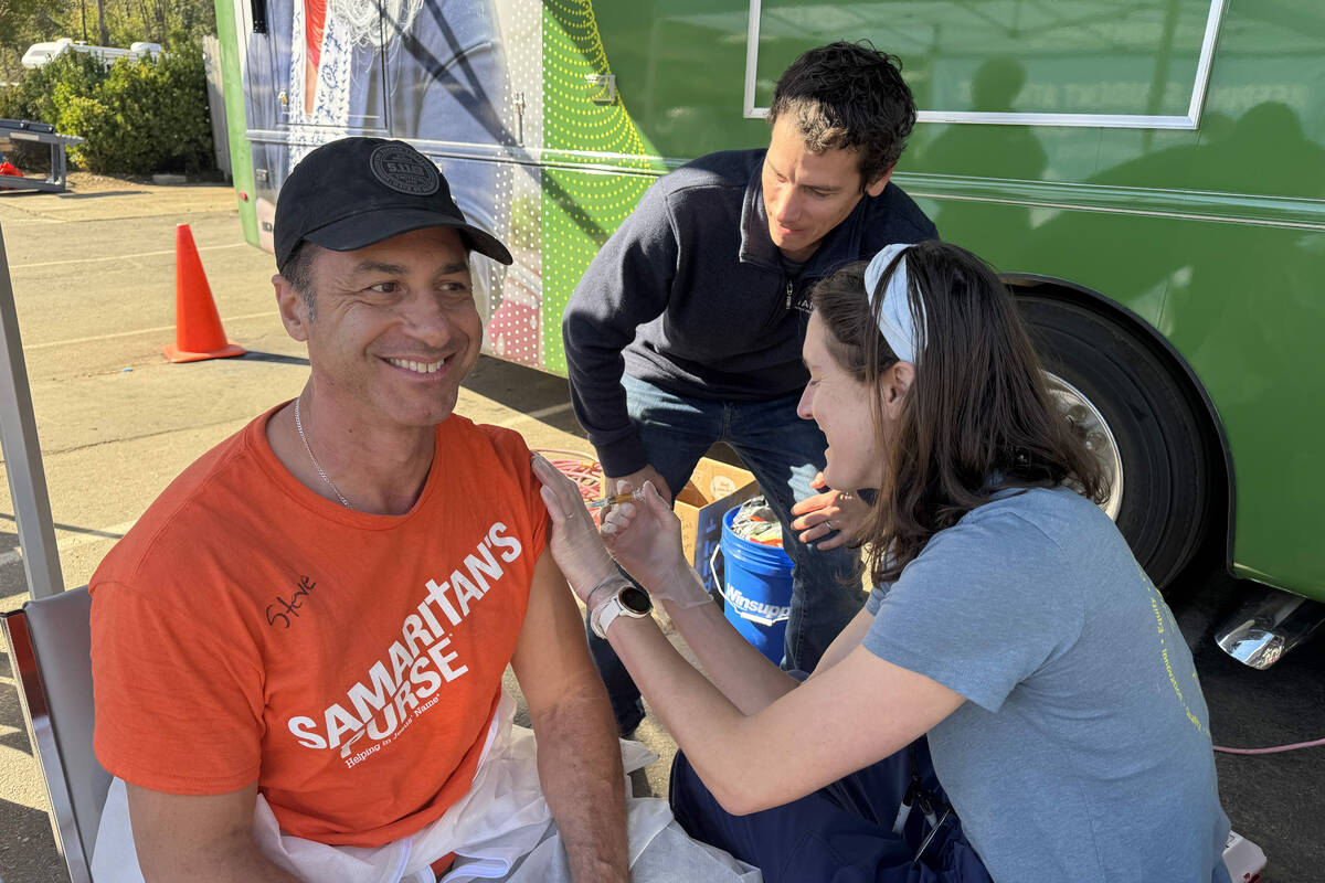 Steven Pieri gets a tetanus shot while he and volunteers with Samaritan’s Purse work on ...