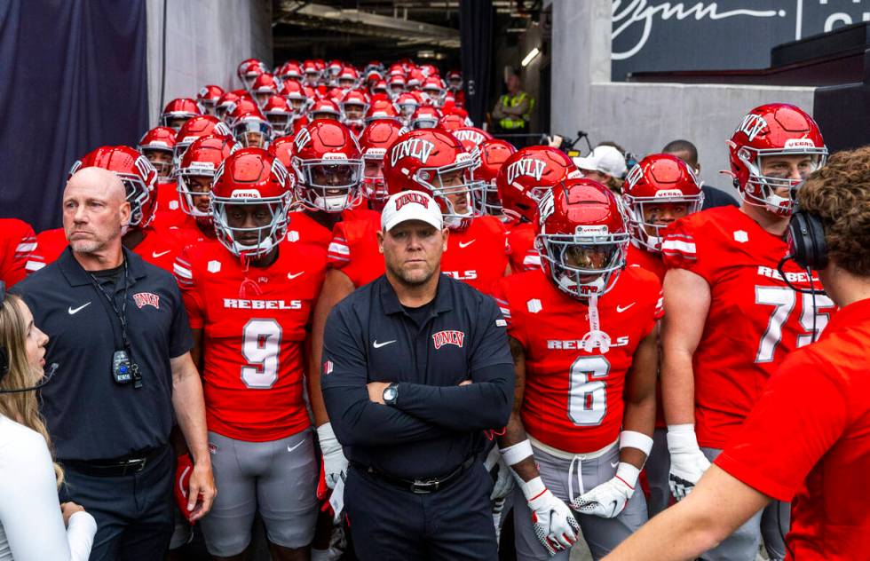 UNLV Head Coach Barry Odom and players await introduction as the ready to face the Fresno State ...