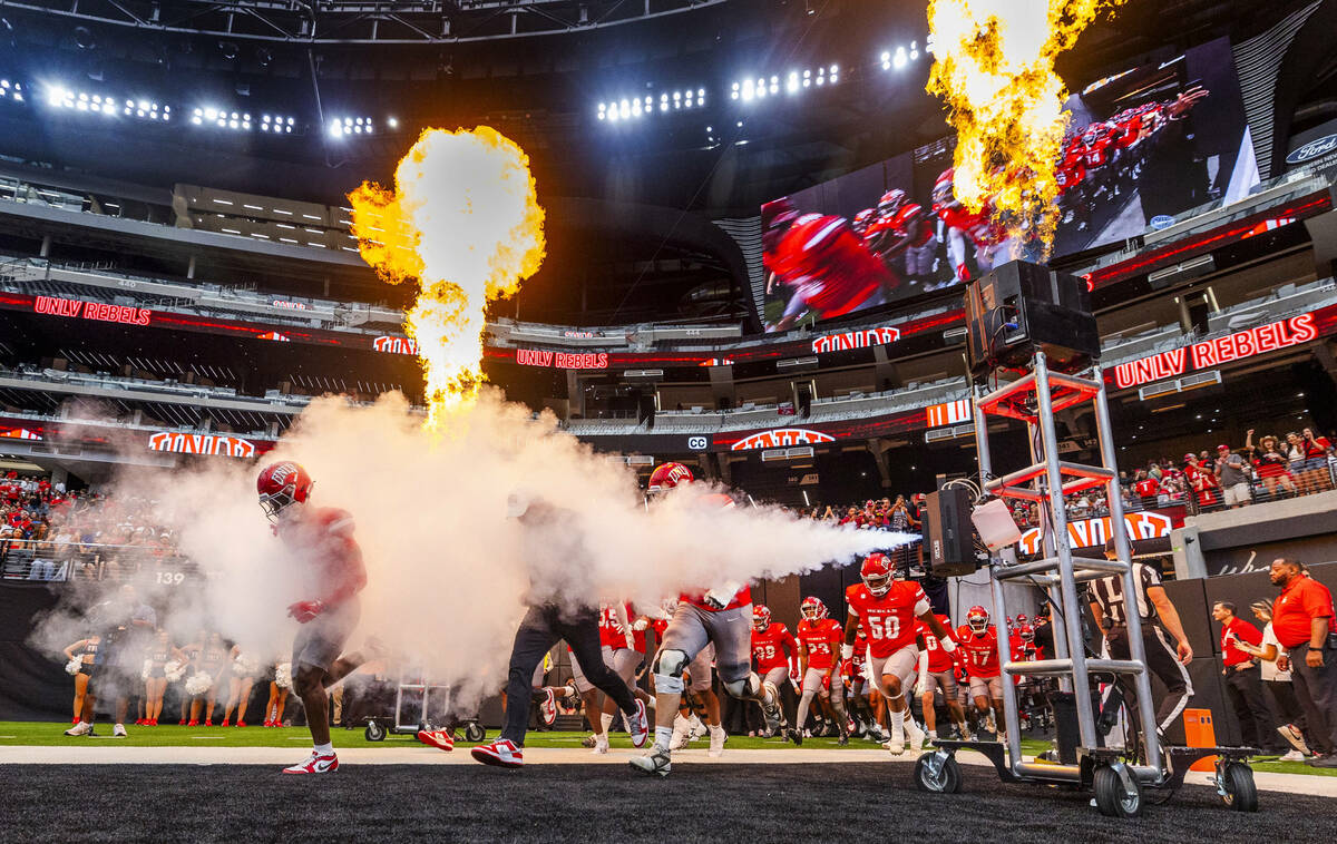 UNLV Head Coach Barry Odom and players take to the field through smoke and fire as the ready to ...