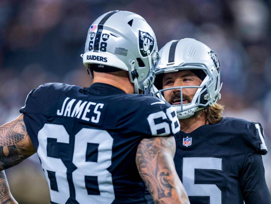 Raiders center Andre James (68) chats with quarterback Gardner Minshew (15) as they face the Da ...