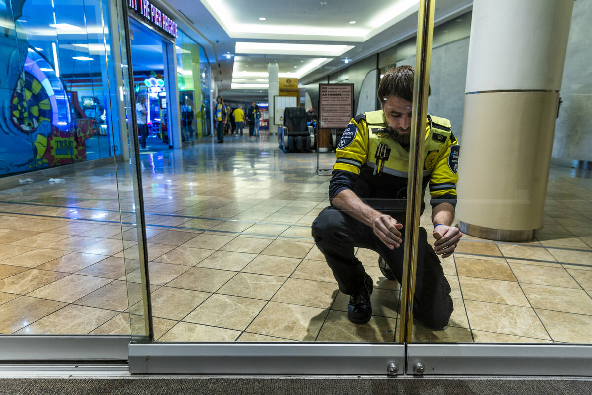 Travis Morin with mall security locks the entrance doors at 9 p.m. as voters still stand in lin ...