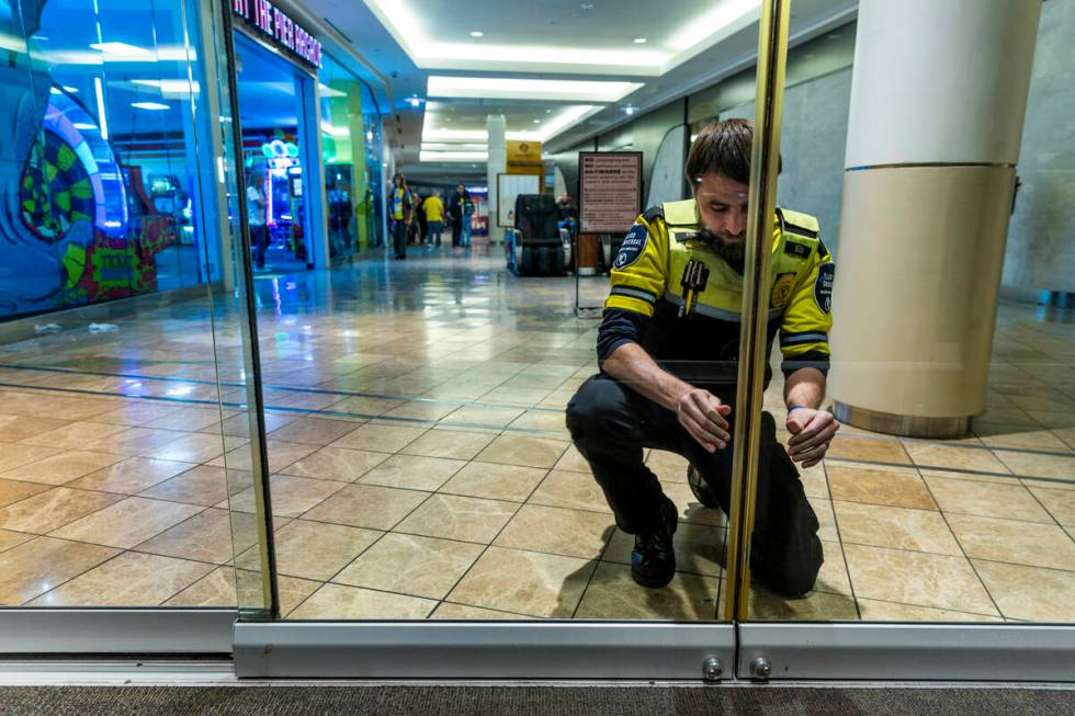 Travis Morin with mall security locks the entrance doors at 9 p.m. as voters still stand in lin ...