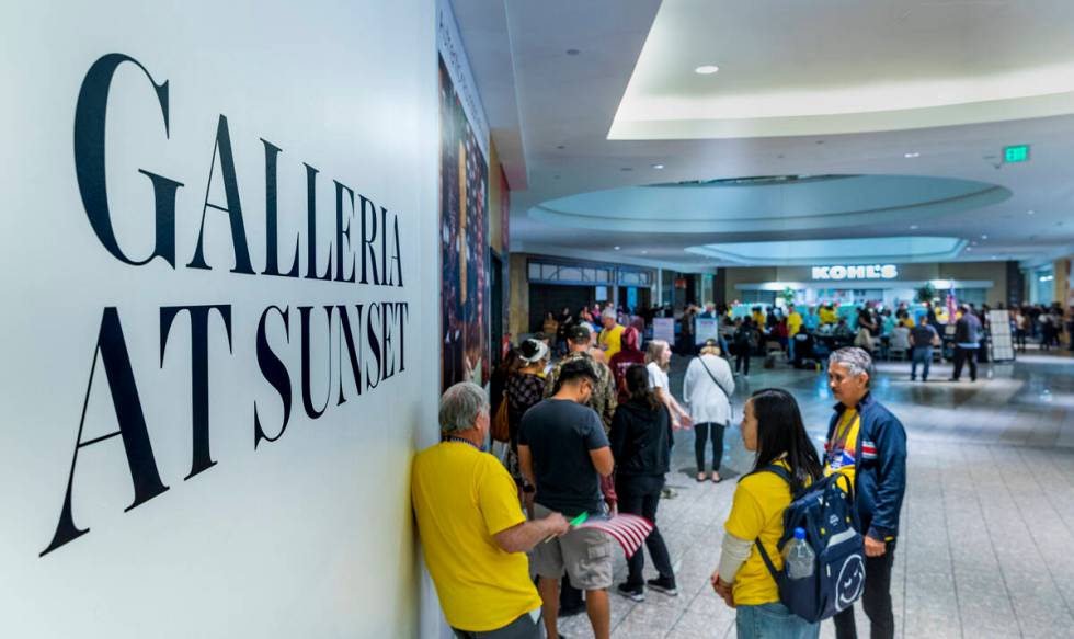 The last voters stand in line to cast their ballots in a polling spot in the Galleria at Sunset ...