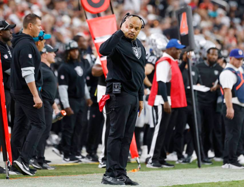 Raiders head coach Antonio Pierce signals as he watches the game from the sidelines during the ...