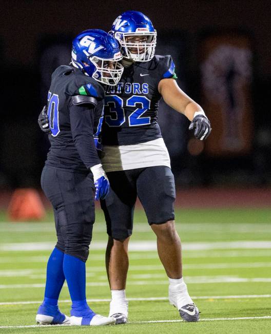 Green Valley senior Shawn Mckeon (50) and senior Richard Aiono (32) celebrate a play during the ...