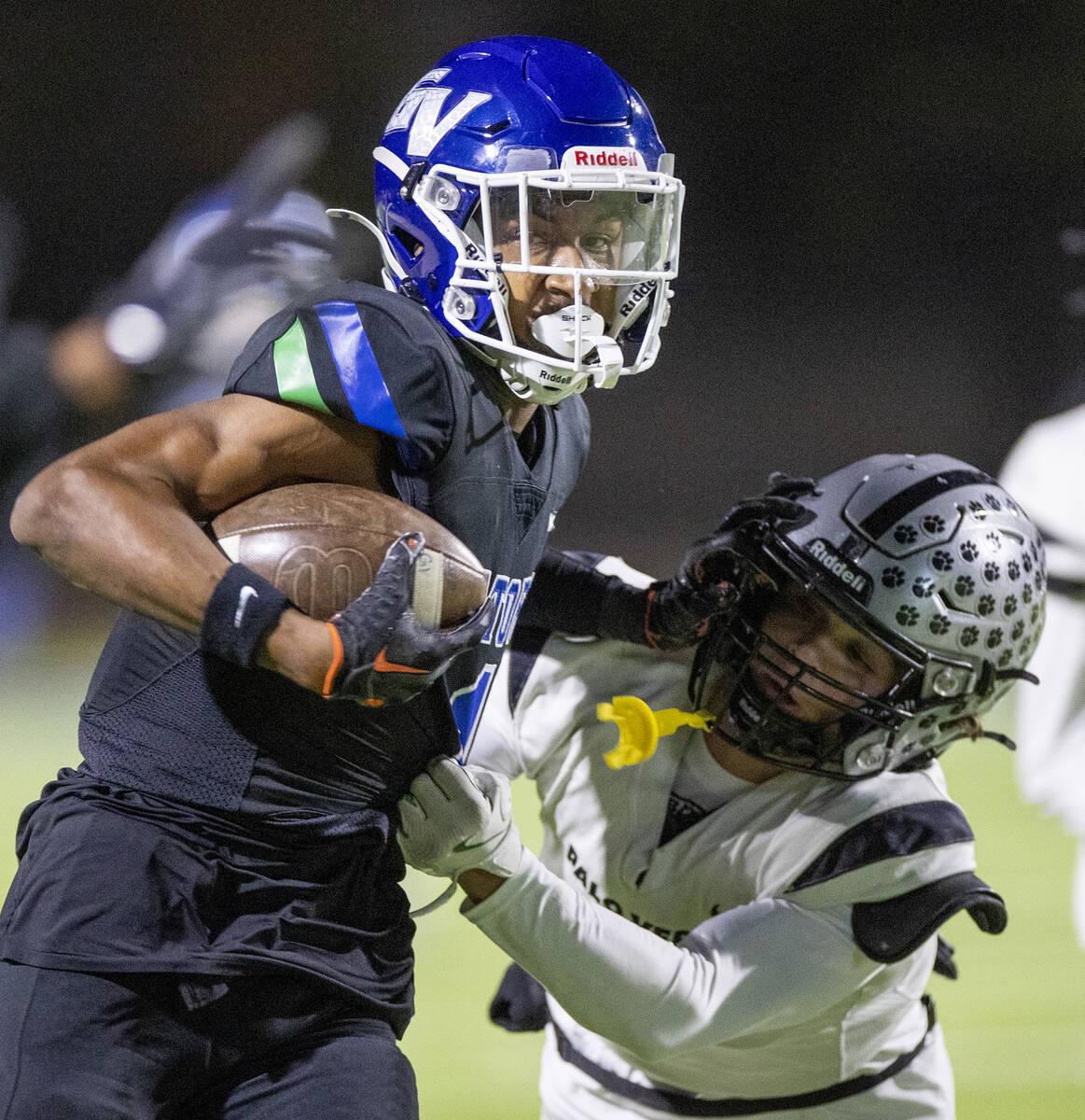 Green Valley senior Trey Glasper, left, stiff arms Palo Verde junior Leo Templeton, right, duri ...