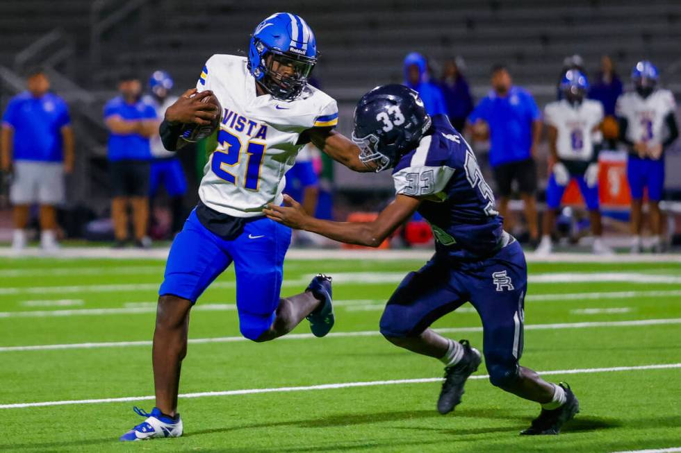 Sierra Vista running back Christian Lee (21) stiff arms Shadow Ridge safety Mujahid Gilliard (3 ...