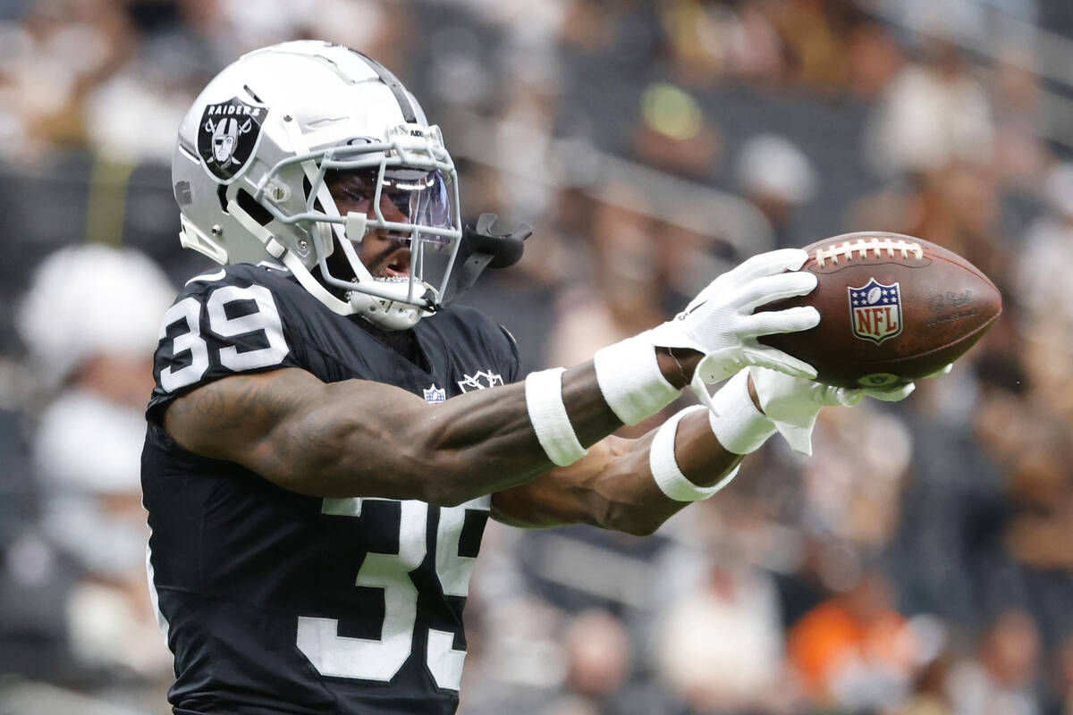 Raiders cornerback Nate Hobbs (39) catches the ball as he warms up before an NFL game against ...