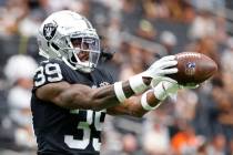 Raiders cornerback Nate Hobbs (39) catches the ball as he warms up before an NFL game against ...