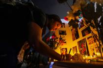 Neysha Velasquez signs a memorial book during a vigil for 17-year-old Jonathan Lewis, on the on ...