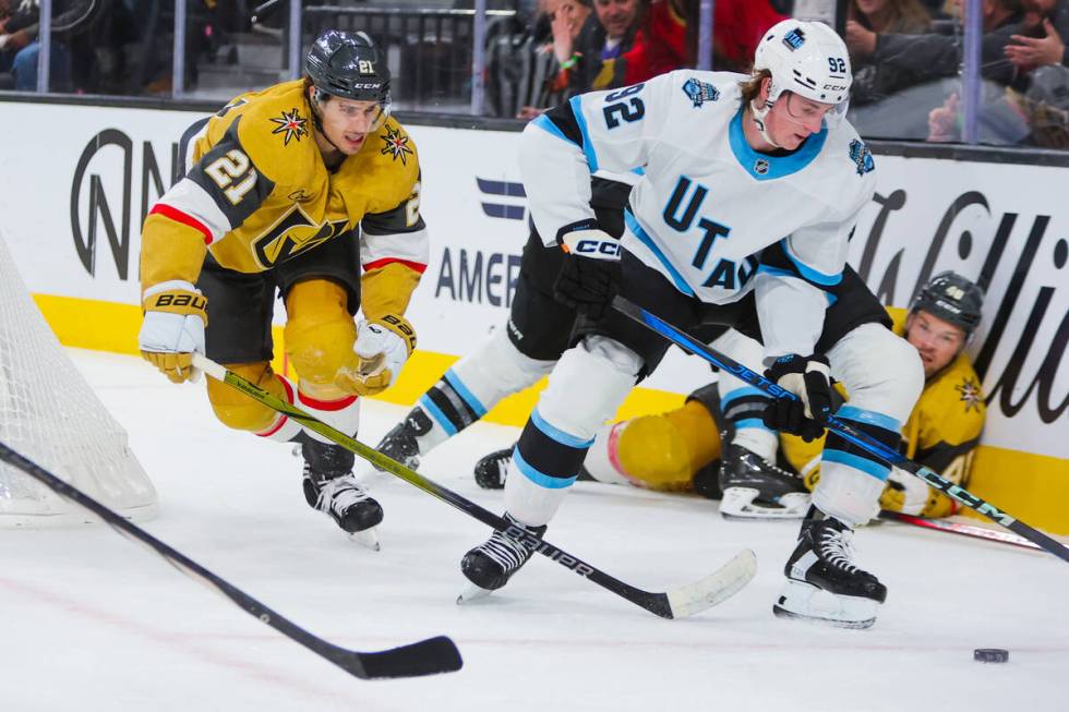 Golden Knights center Brett Howden (21) races Utah Hockey Club center Logan Cooley (92) for the ...