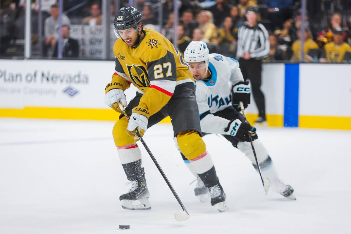 Golden Knights defenseman Shea Theodore (27) skates the puck across the ice during overtime in ...