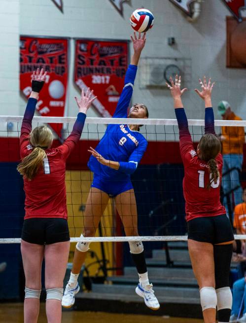 Bishop Gorman's Ayanna Watson (8) goes up high to tip the ball back over the net past Coronado' ...