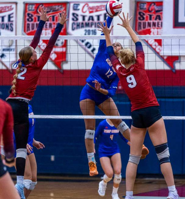 Bishop Gorman's Brooklynn Williams (12) spikes the ball past Coronado's Julie Beckham (2) and R ...