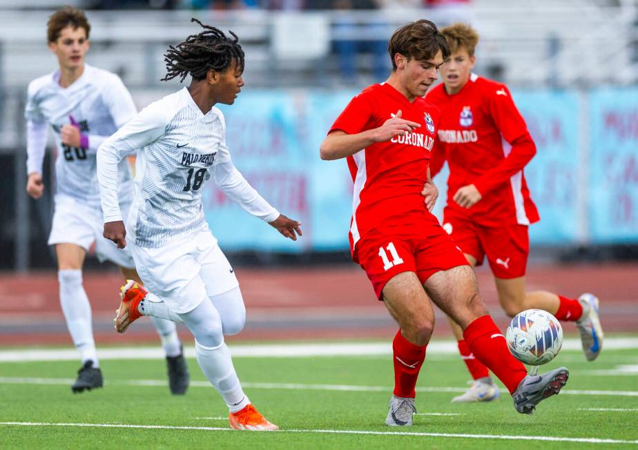 Coronado striker Gavin Flickinger (11) kicks the ball past Palo Verde halfback Shilo Stephenson ...