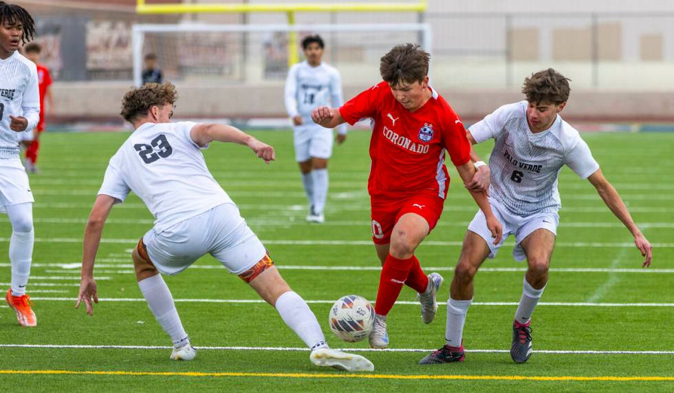 Coronado midfielder Aiden Sena (10) splits the defense of Palo Verde defender Ben Legrand (23) ...