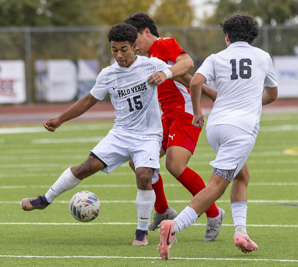 Palo Verde forward Trevon Aytch (15) passes the ball to teammate midfielder Daniel Maldonado (1 ...