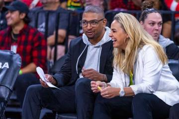 Aces head coach Becky Hammon laughs on the bench with assistant coach Tyler Marsh against ...