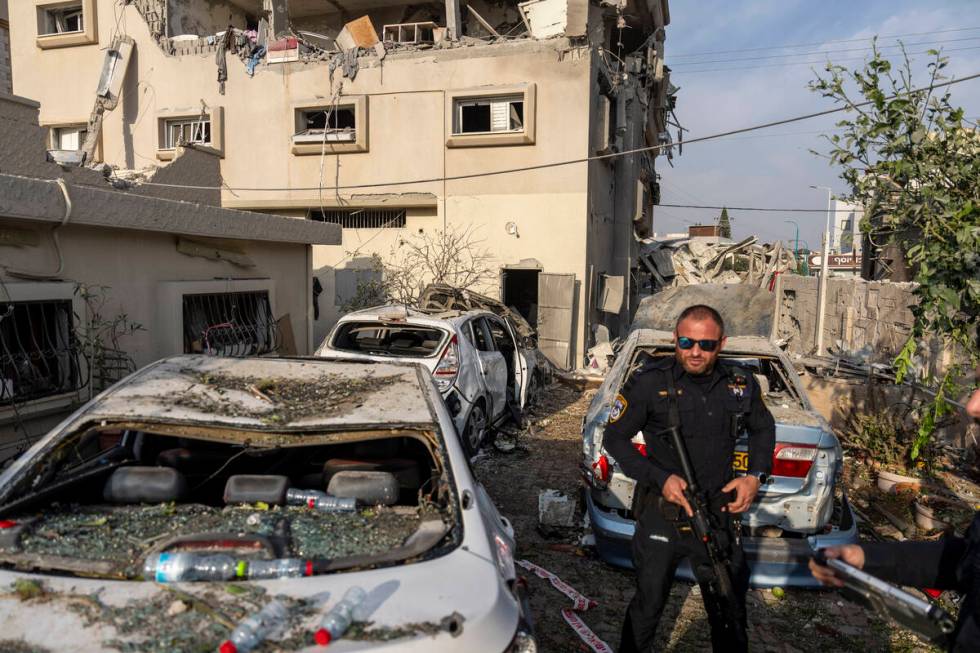 Israeli police men work at the site where projectiles fired from Lebanon hit a home in Tira, ce ...