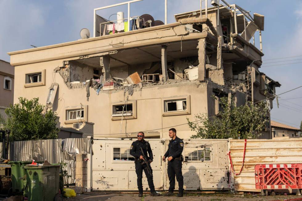 Israeli police men work at the site where projectiles fired from Lebanon hit a home in Tira, ce ...