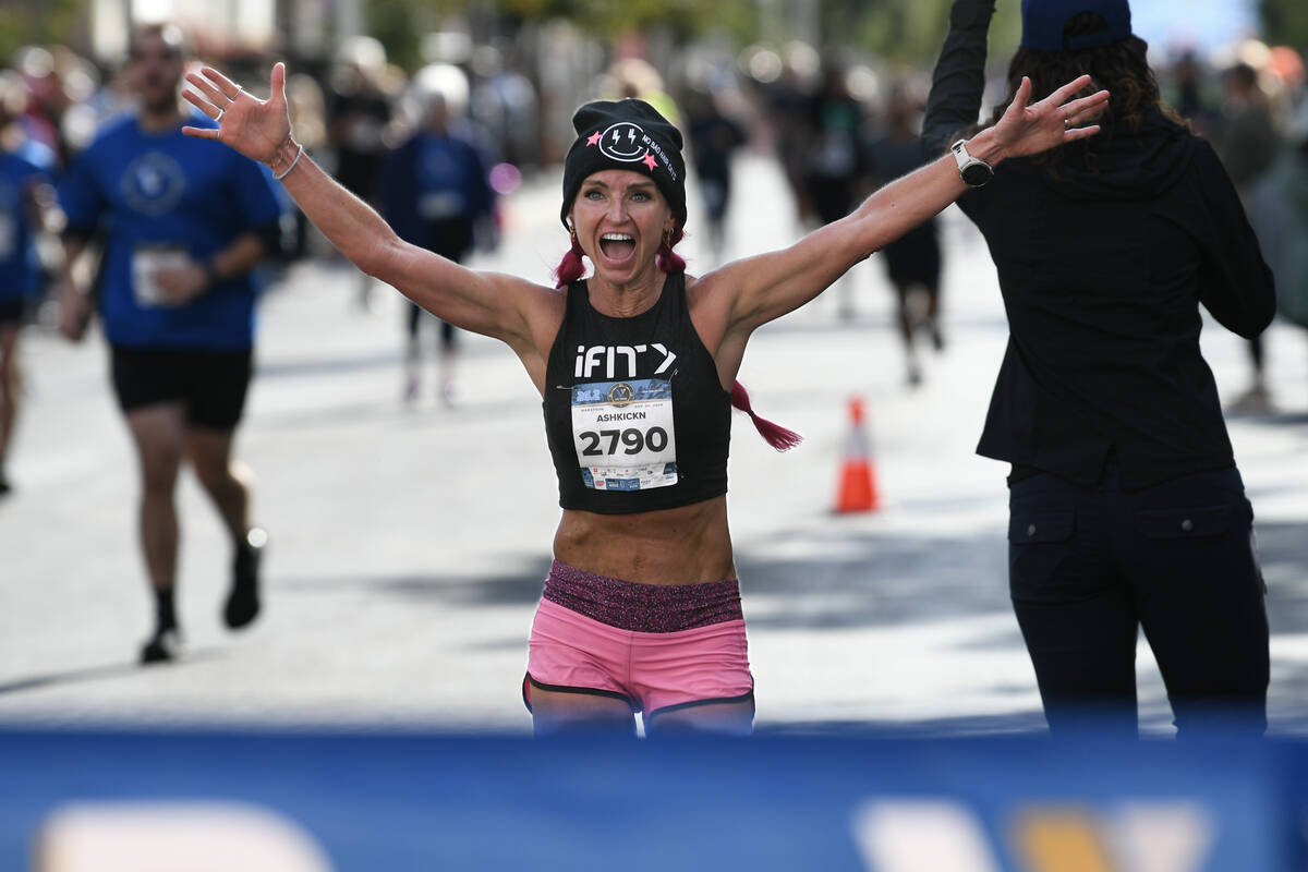 Women’s marathon first place finisher Ashley Paulson crosses the finish line during the Las V ...