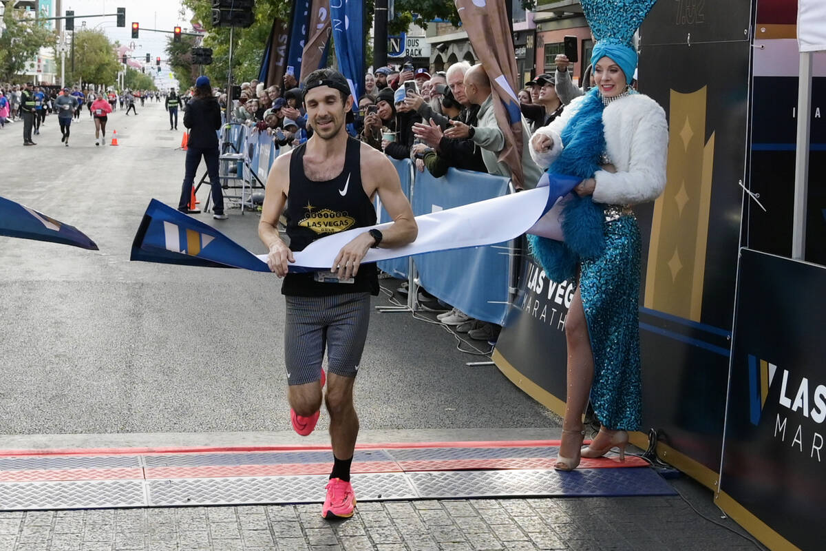 Men’s marathon first place finisher J.J. Santana crosses the finish line during the Las Vegas ...