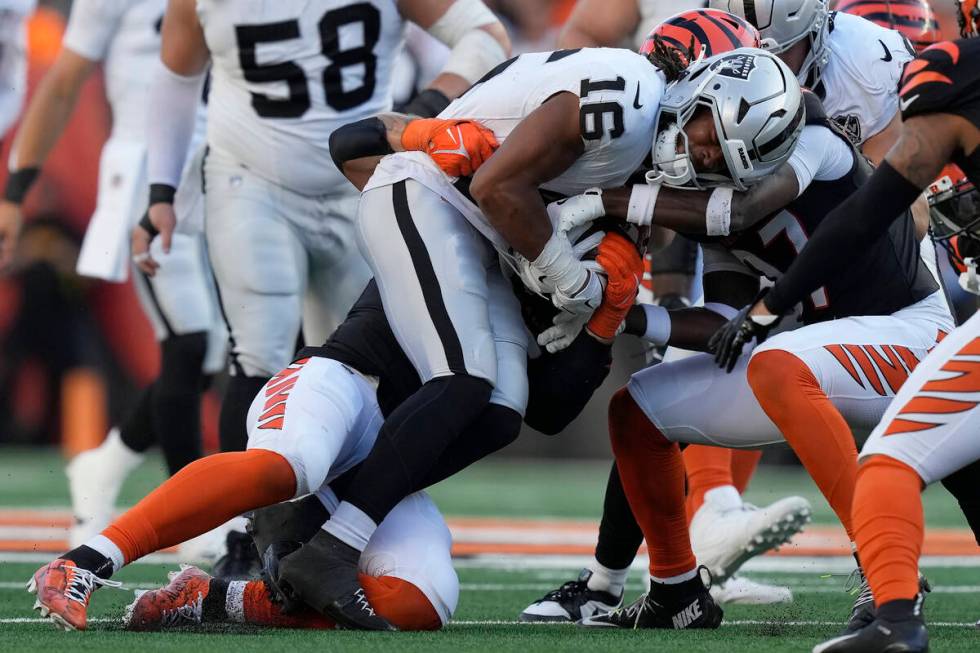 Las Vegas Raiders wide receiver Jakobi Meyers (16) is tackled by Cincinnati Bengals players dur ...