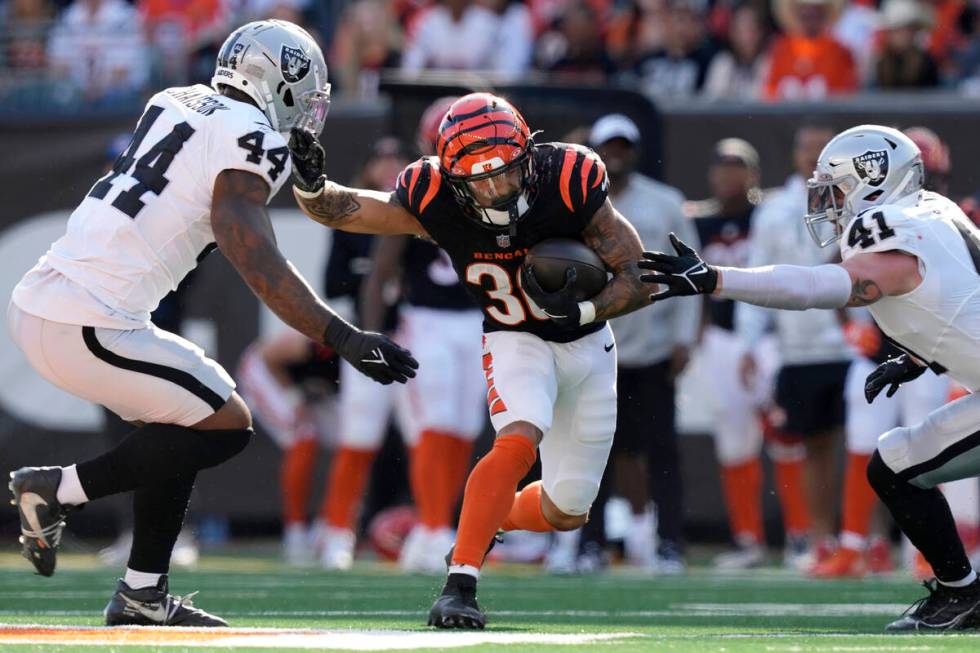 Cincinnati Bengals running back Chase Brown, middle, runs against Las Vegas Raiders defensive e ...