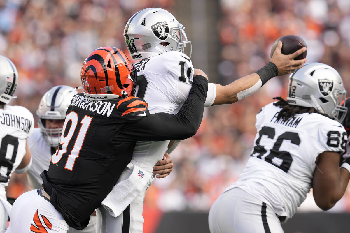 Cincinnati Bengals defensive end Trey Hendrickson, left, sacks Las Vegas Raiders quarterback De ...