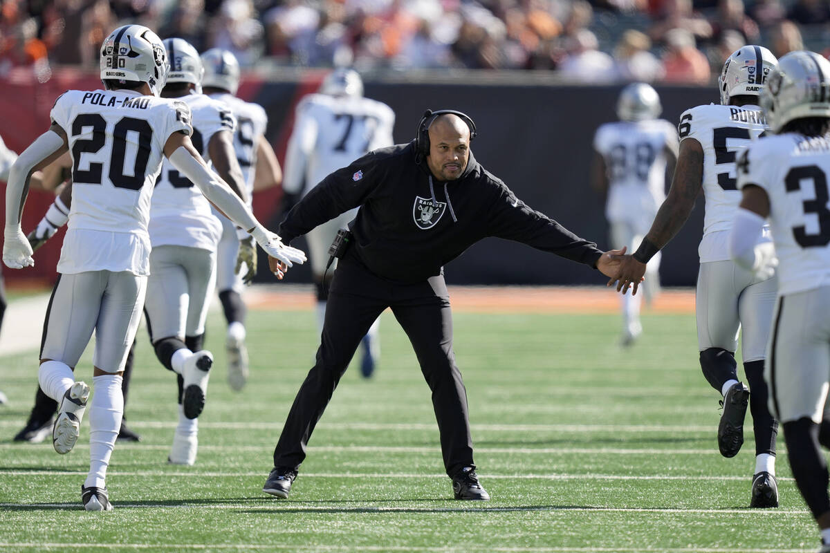 Las Vegas Raiders head coach Antonio Pierce, middle, greets players before an NFL football game ...