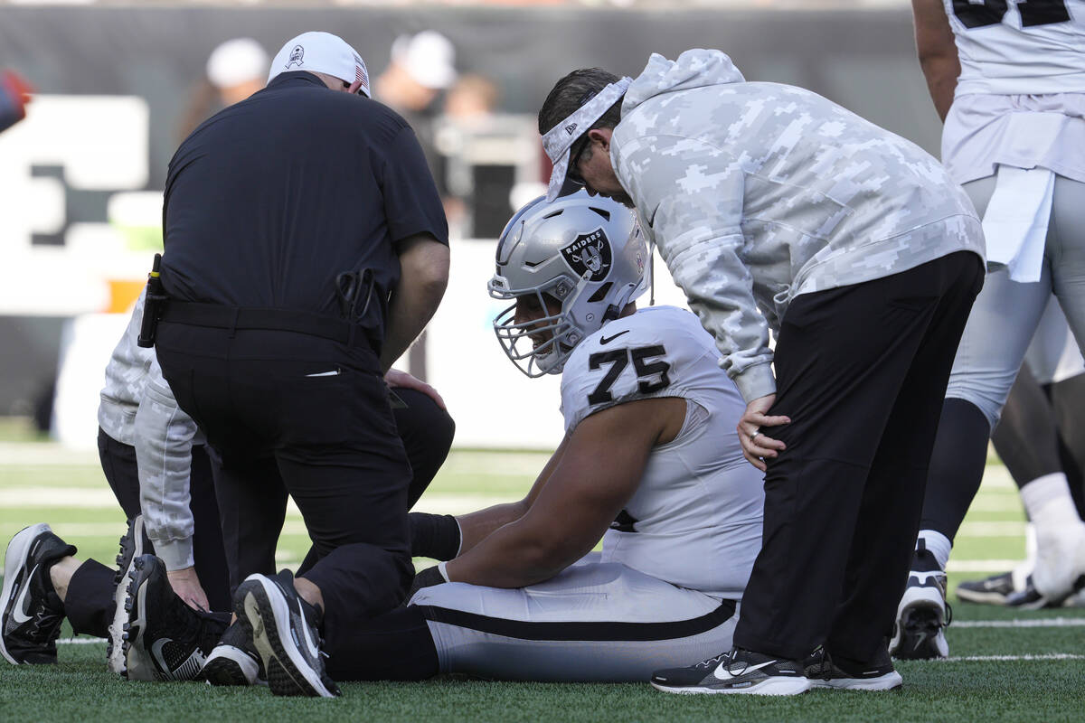 Las Vegas Raiders guard Andrus Peat (75) is tended to during the first half of an NFL football ...