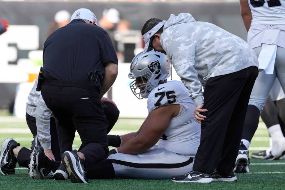 Las Vegas Raiders guard Andrus Peat (75) is tended to during the first half of an NFL football ...