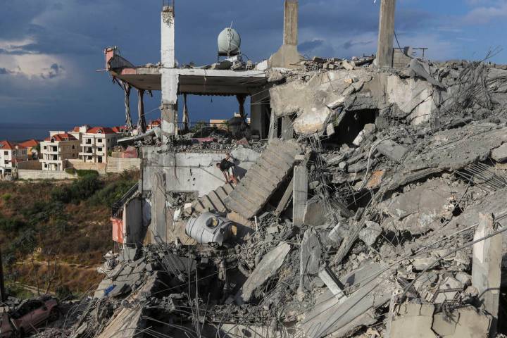 A man inspects a destroyed building hit in an Israeli airstrike, in Ghaziyeh town, south Lebano ...